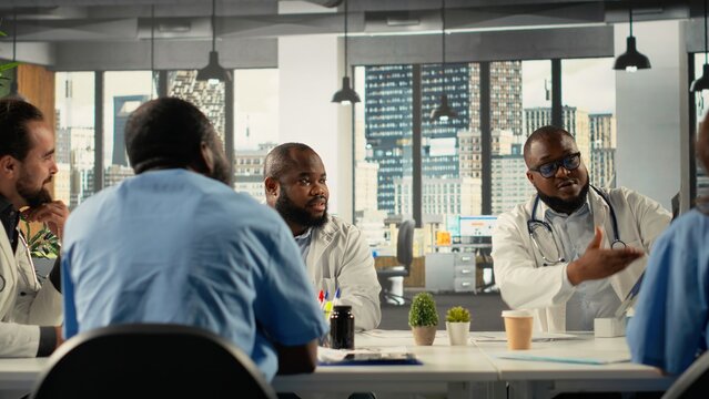 Diverse professionals collaborating in brainstorming session for healthcare. Team sharing medical expertise and diagnostic solutions for improved therapy at clinic, medical staff.