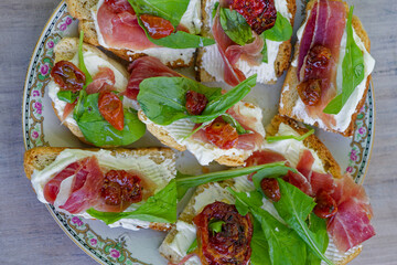Plate of fresh bruschetta appetizers topped with various italian ingredients