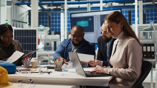 Factory manager looking over paperwork files, developing business model, expanding production. Employee reading documentation files, integrating automation technology in industrial plant, camera A