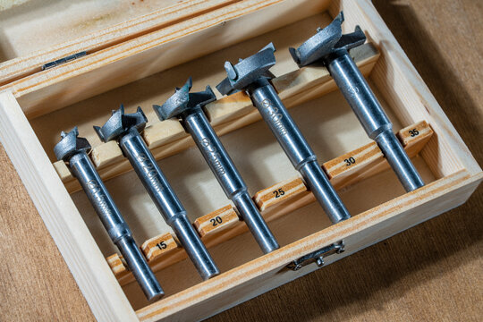 A set of Forstner drills bit of different diameters for making holes in wood products, closeup. Carpentry drill, used to mount furniture hinges. A cutter used to mount furniture from chipboard - Powered by Adobe