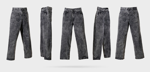 Black male acid wash denim jeans with wide leg and fading from different sides on light gray background. Concept of trendy vintage, men's street fashion denim clothing. Template for design. Banner