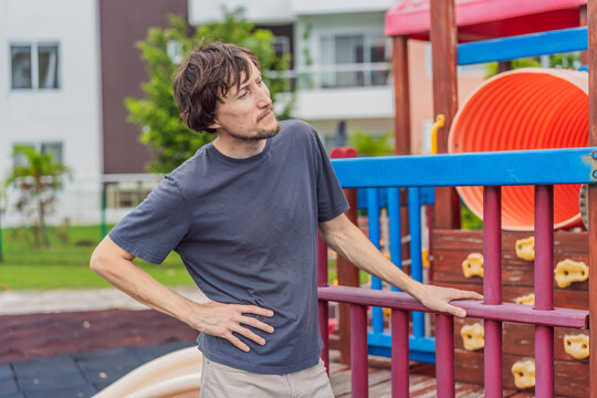 A man playing with his small son on a playground, laughing and engaging in active fun together in a bright outdoor setting. Family bonding, early childhood development and healthy outdoor lifestyle