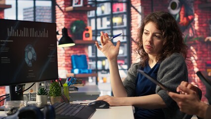 Team of analysts examining presentation charts and data on dashboard, using analytics tools to help monitoring business statistics. People analyze performance metrics and diagrams. Camera B.