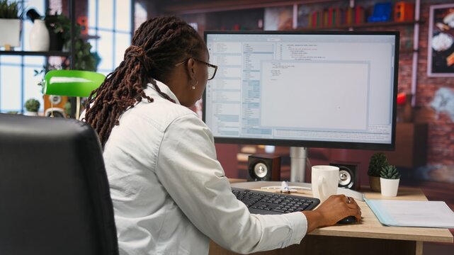 Coder at workstation programming on PC, writing lines of code, using development tools, feeling stressed. Woman in home office having deadline, stressed to finish debugging software, camera B