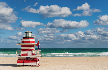 Obraz premium Lifeguard over Miami beach. Panoramic seascape of Miamis famous coastline. South Miami Beach. Miami Beach jetty. Rescue tower against the blue sky in Miami. Beautiful coastal view of Florida.