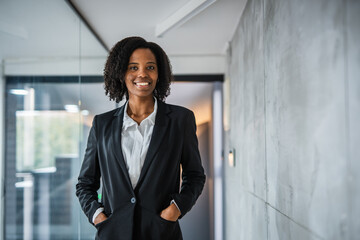 Confident african american businesswoman standing in modern office