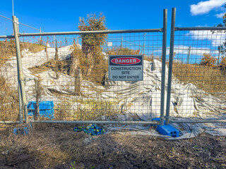 Photograph of a Danger Warning Sign on a fence barricade notifying people not to enter a small construction site in regional New South Wales, Australia. 