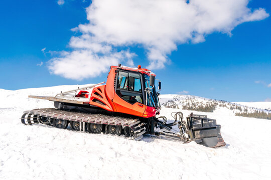 Snowcat ratrack with snowplow,snow grooming machine,remover truck preparing ski slope,piste,hill at alpine skiing winter resort. Heavy machinery,tractor mountain equipment track vehicle