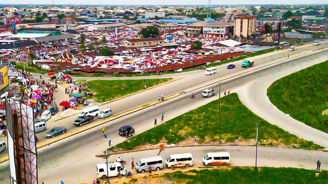 Aerial view of the bustling Port Harcourt/Aba Expressway intersects with a vibrant market, a symphony of motion and commerce, Port Harcourt, Rivers State, Nigeria.