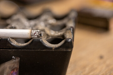 Close-Up of a Man Putting a Cigarette in an Ashtray
