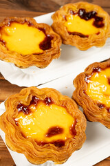 angle view portuguese egg tarts on a wooden table at vertical composition