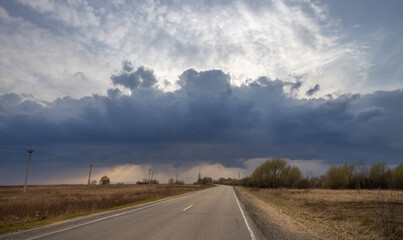Long road with a cloudy sky in the background