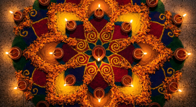 Diwali Celebration: Illuminated Rangoli Pattern with Clay Diya Lamps and Marigold Flowers