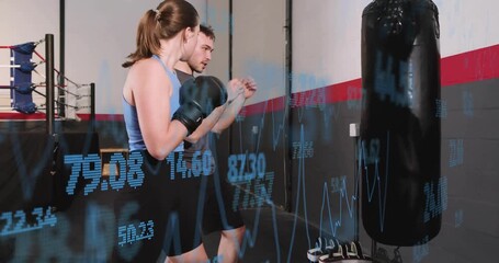 Female boxer stepping in and throwing jabs at heavy bag, coach guiding while overlay tracking data - Powered by Adobe