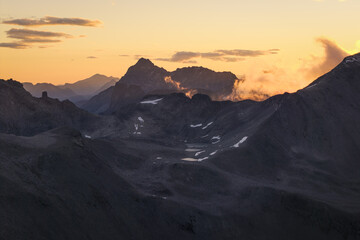 Aerial view of rugged peaks and valleys painted with the warm hues of the setting sun, Trollstigen, More og Romsdal, Norway.