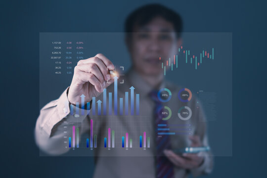 Businessman analyzing futuristic financial dashboard with data charts, bar graphs, pie charts, and digital investment statistics