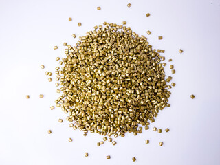plastic masterbatch, gold masterbatch granules as virgin polymer resin pigment, poured into white background media, suitable for industrial plastic company profile product catalog design, top view
