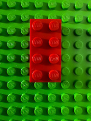 Fototapeta premium BELO HORIZONTE, MG, BRAZIL – NOVEMBER, 22, 2025: A red Lego brick centered on a green Lego baseplate.