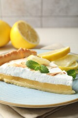 Slice of tasty lemon meringue tart served on table, closeup