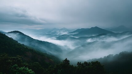 Misty mountain range shrouded in atmospheric fog, evoking a sense of serene wilderness and natural beauty