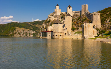 Nine tall towers of Golubac fortress are interconnected by wide stone walls. Medieval defensive structure, heritage of Hungarian, Turkish, Polish nation.