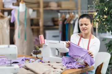 Experienced asian female seamstress dissatisfied with quality of stitching or broken sewing machine...