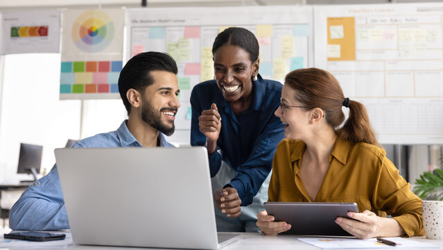Multiethnic business team of happy coworkers discussing online project presentation