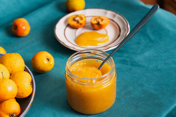 Homemade medlar jam in glass jar with fresh fruit