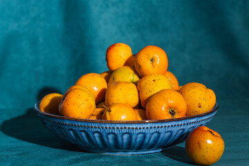 Tejocotes fruit filling blue ceramic bowl