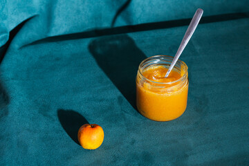 Tejocote jam in jar with spoon and raw apple