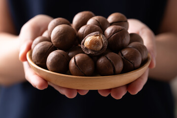 Macadamia nuts in a bowl holding by hand