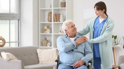 Obraz premium Female doctor hugging mature man in wheelchair at home