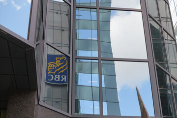 Obraz premium reflection of RBC (Royal Bank of Canada) corporate logo sign on a mirror glass window in downtown Toronto