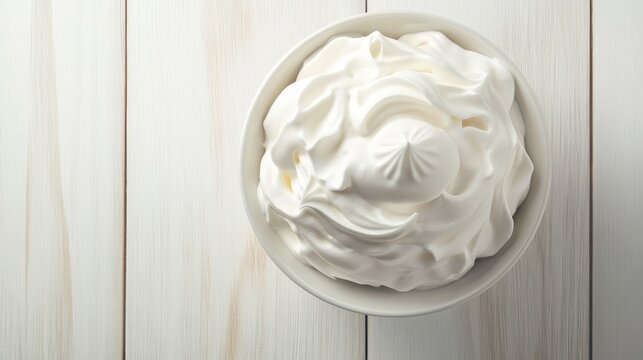 Airy whipped egg whites with soft peaks in vintage white ceramic bowl, positioned on matte white wooden kitchen table, overhead composition, morning light streaming in, macro detail of delicate foam