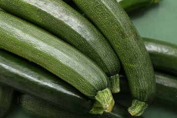 Many fresh zucchini on green background, closeup