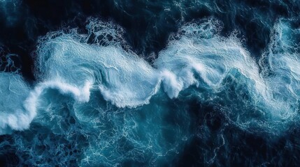 Aerial view of dark blue ocean waves crashing and creating white sea foam with dynamic swirling patterns