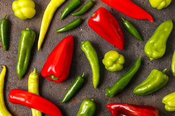 Obraz premium Different fresh peppers on dark background