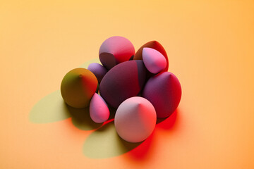 Different makeup sponges on orange background