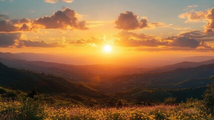 Fototapeta premium Golden sunset over rolling mountains with clouds and field of yellow flowers in foreground creating a peaceful and warm atmosphere
