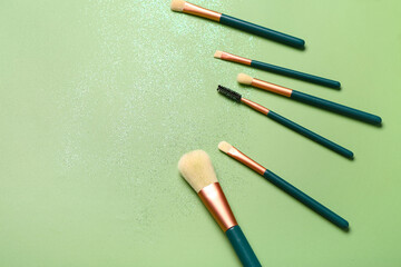 Makeup brushes on green background