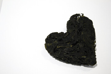 Heart-shaped Undaria pinnatifida placed on a white background.