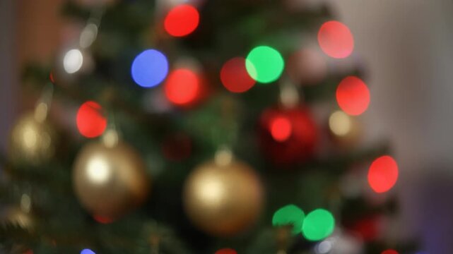 Blurred Christmas Tree with Colorful Blinking Lights and Golden Ornaments