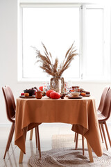 Autumn table setting with pumpkins and pampas grass in light living room