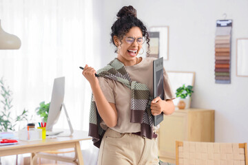 Happy African-American graphic designer with tablet in office