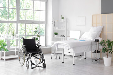 Interior of hospital ward with bed and wheelchair
