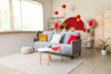 Blurred view of living room with sofa, tables and decor for Japanese New Year celebration