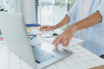 A creative designer works on UX/UI planning, analyzing sketches and prototypes on a whiteboard while using a laptop. The process shows design thinking, user flow, and digital innovation.