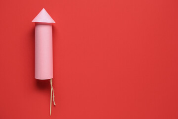 Pink firework rocket on red background