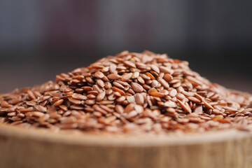 Obraz premium Brown flax seeds piled on a wooden surface