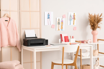 Workplace of clothes stylist with modern printer and laptop in light home office